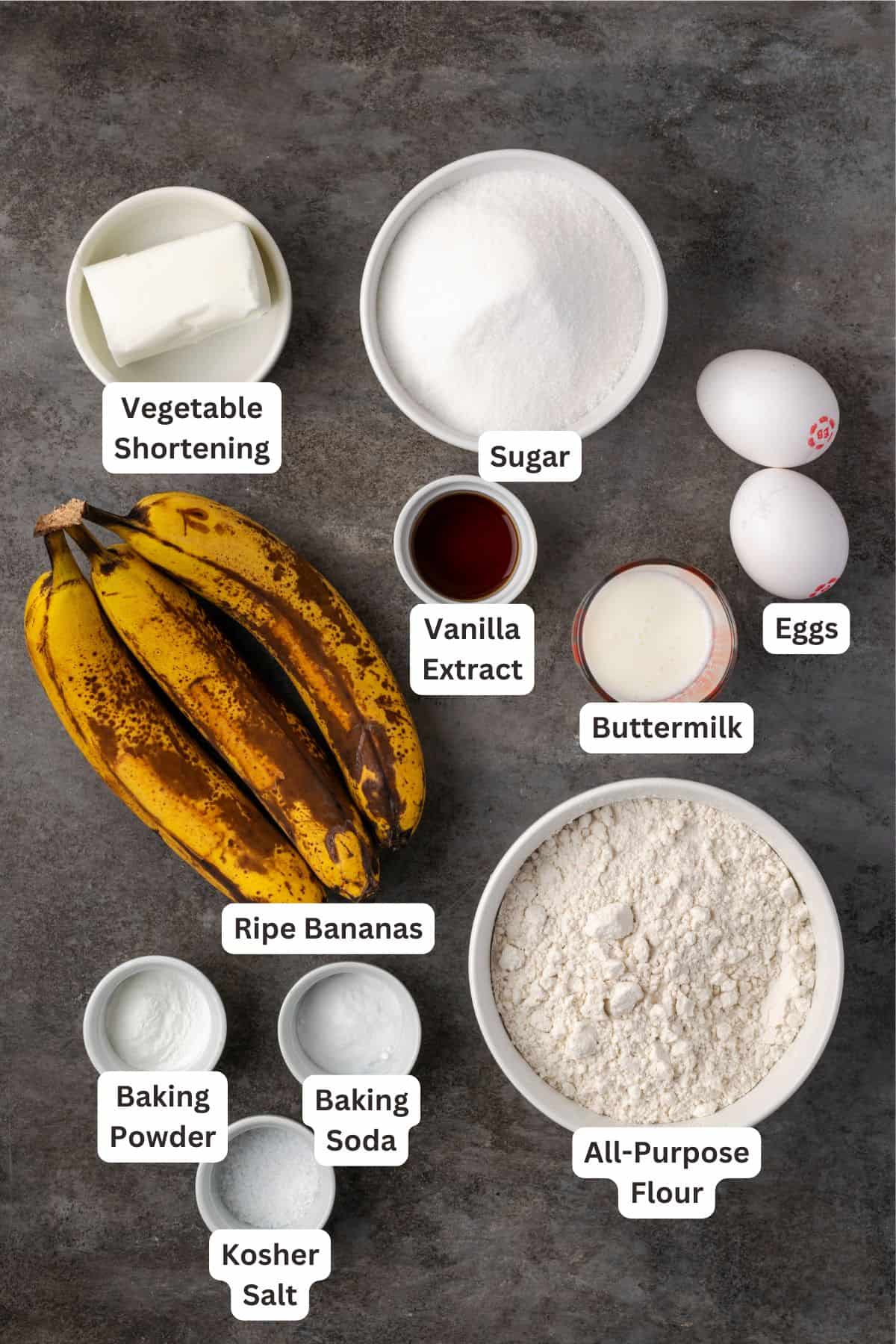 The ingredients for banana cupcakes with text labels overlaying each ingredient.