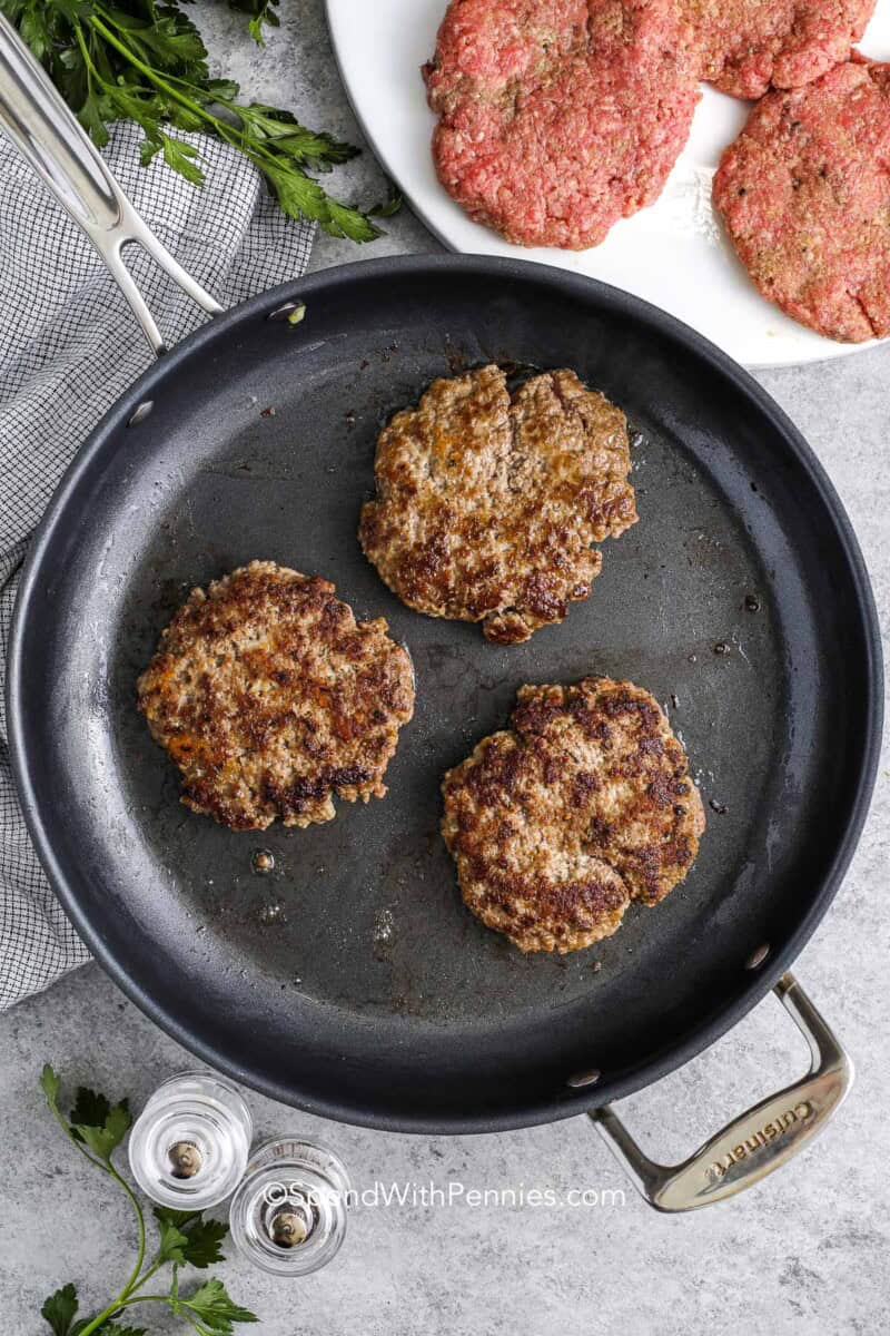 Browned salisbury steak patties in a skillet