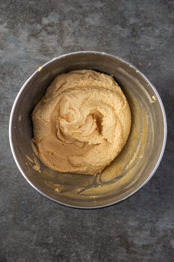 Whipped peanut butter frosting in a metal mixing bowl.