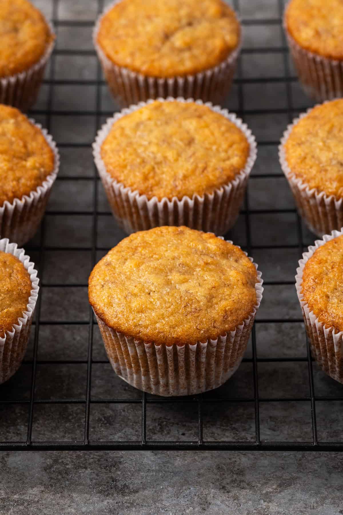 Unfrosted banana cupcakes on a wire rack.