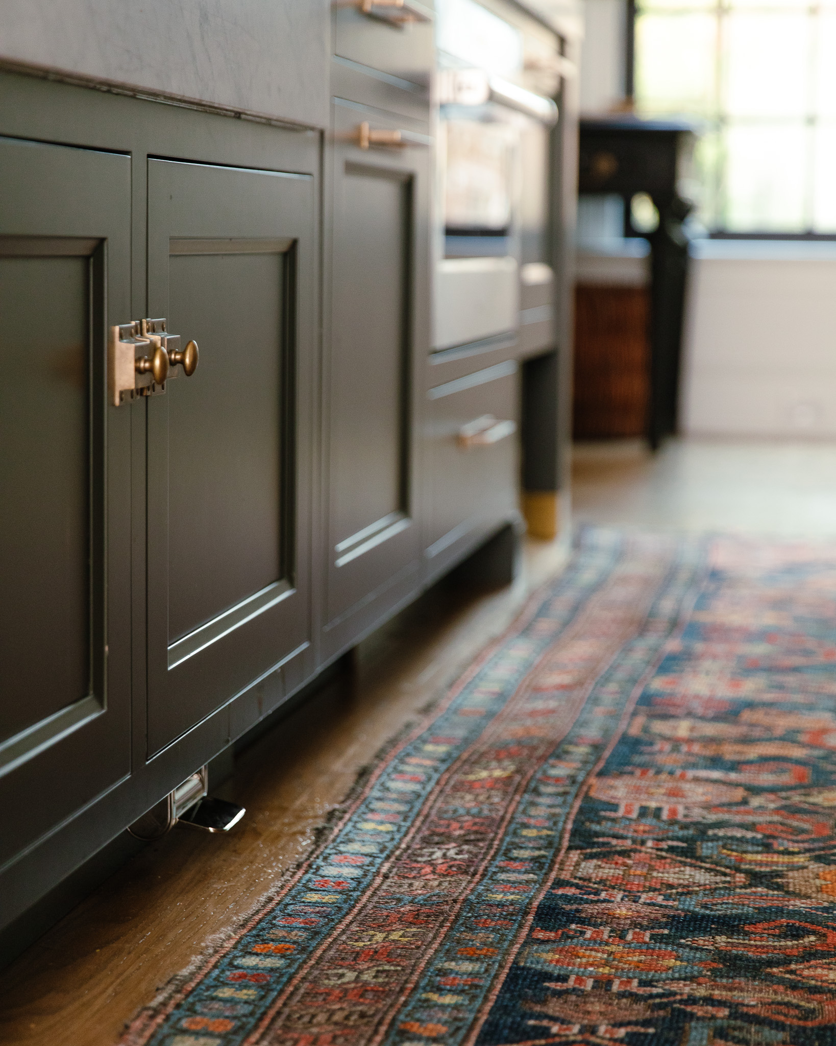 A barely noticeable nickle-plated lever underneath a lower sink cabinet