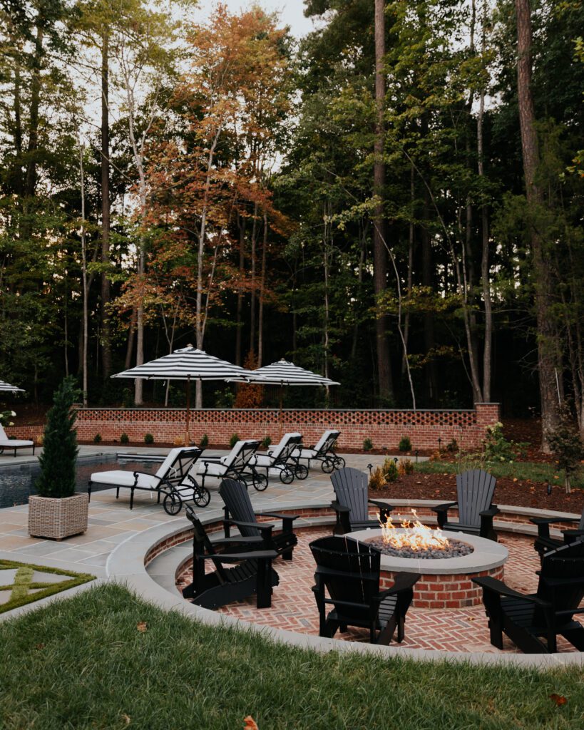 Backyard fire pit with adirondack chairs around it