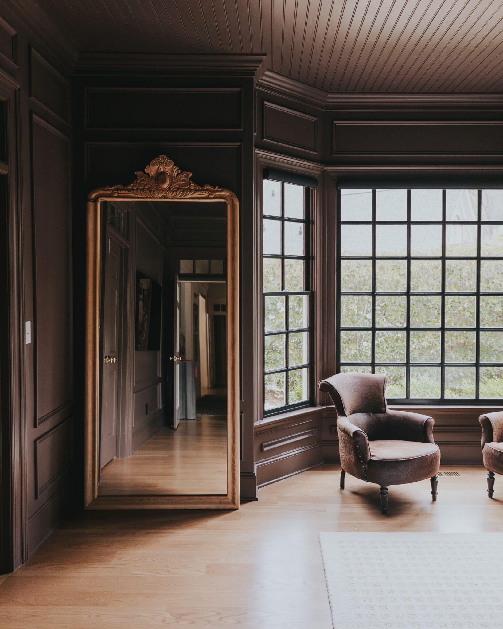 Large gold floor mirror in a primary bedroom