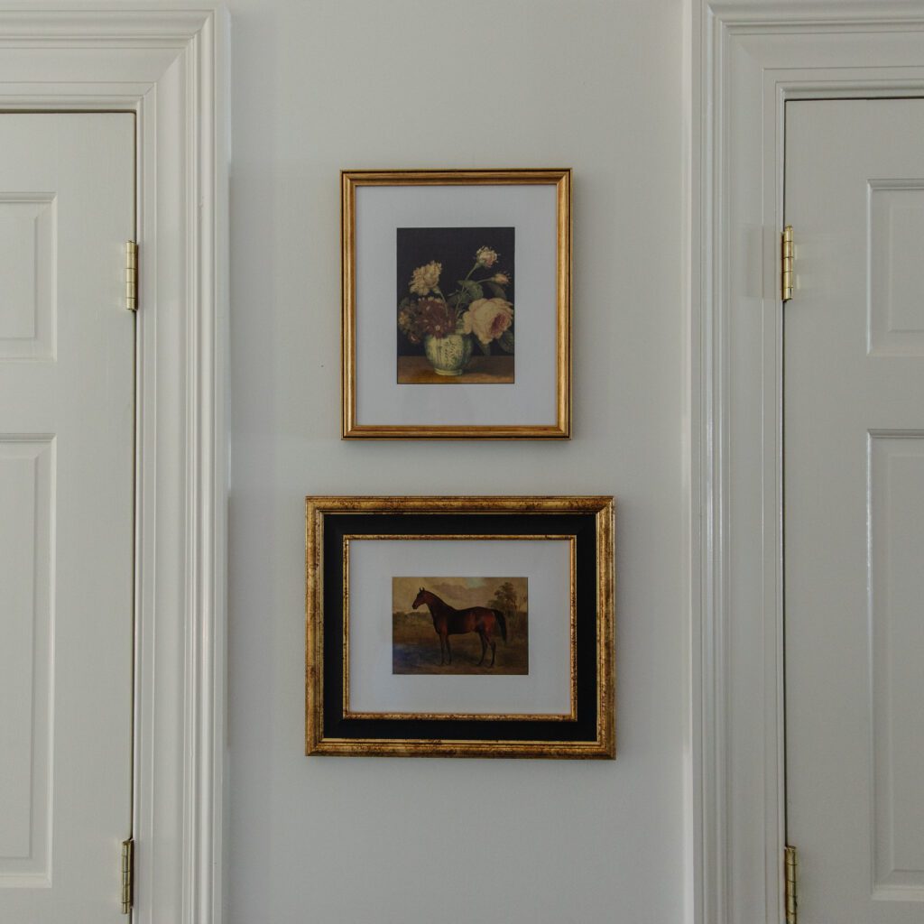 A stack of two framed prints in antique gilded frames