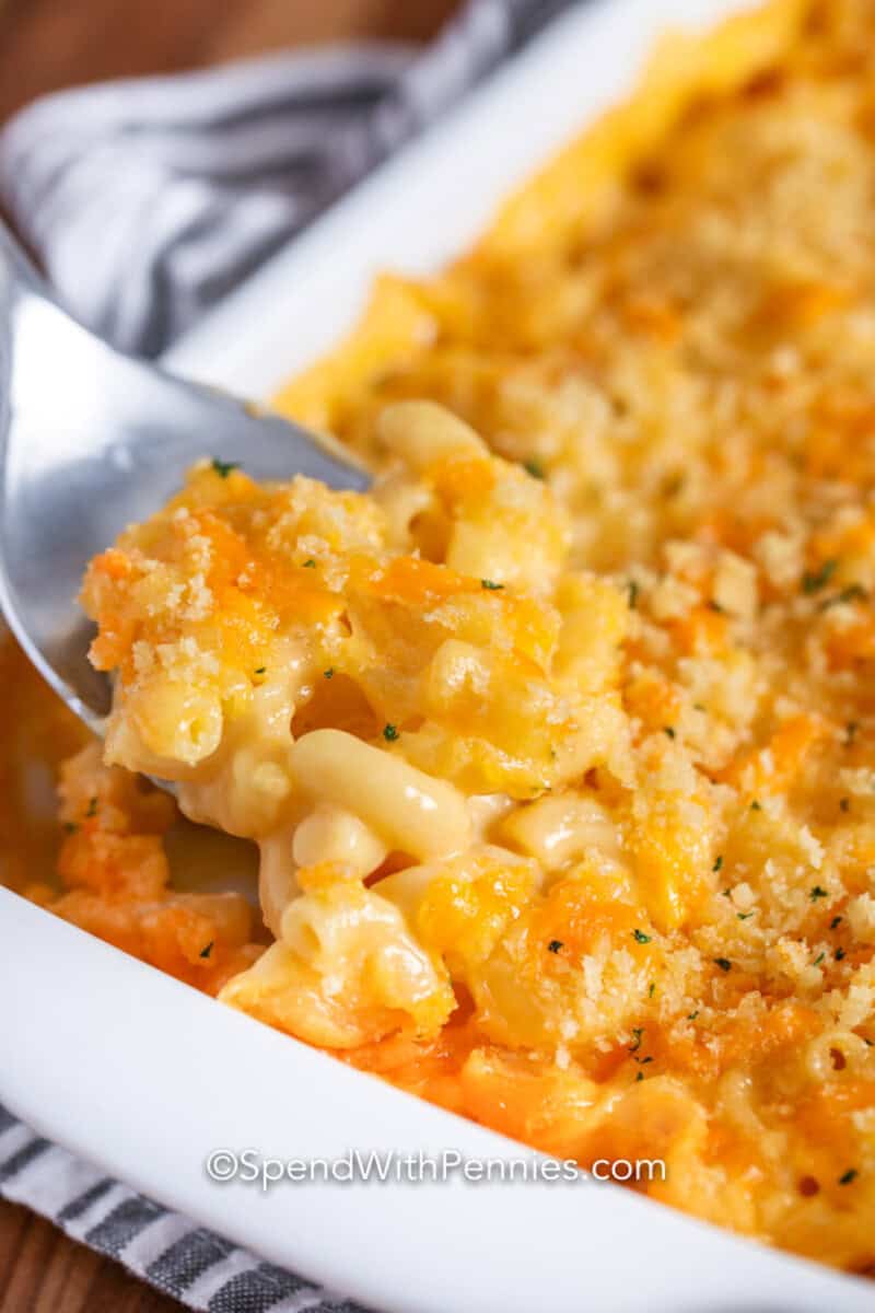 A baking dish of Velveeta mac and cheese with a serving spoon