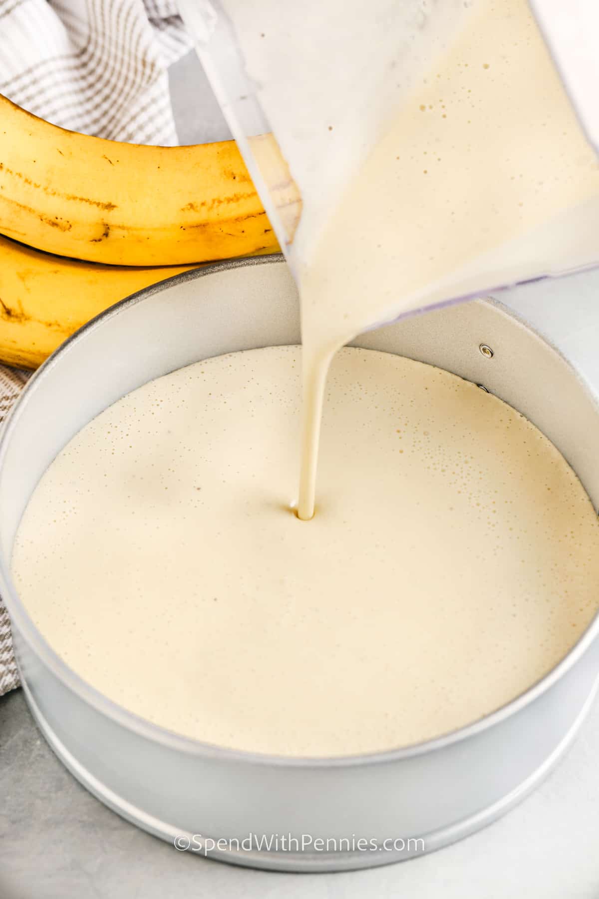 pouring cheesecake layer in a springform pan for banana pudding cheesecake