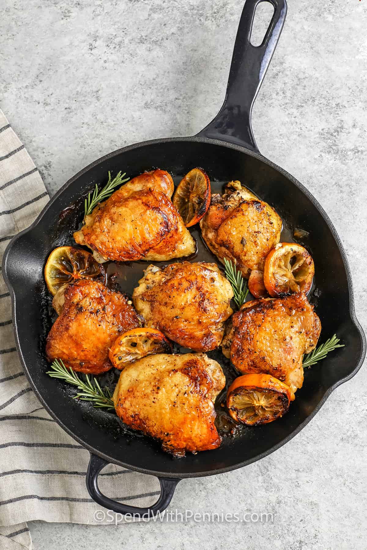 skillet full of Skillet Chicken Thighs with lemon slices