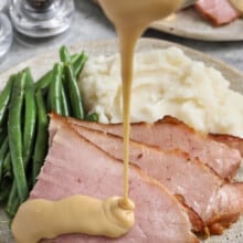 pouring Ham Gravy over slices of ham