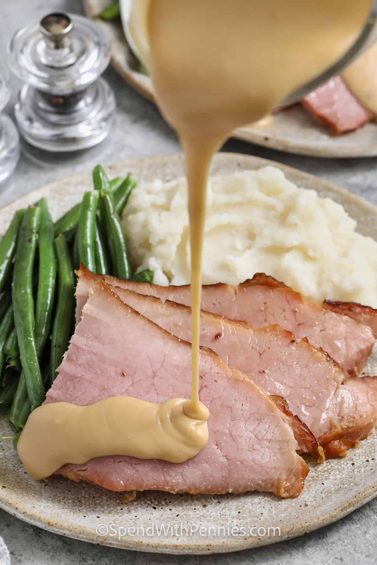 pouring Ham Gravy over slices of ham