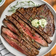 juicy London Broil on a plate with butter on top