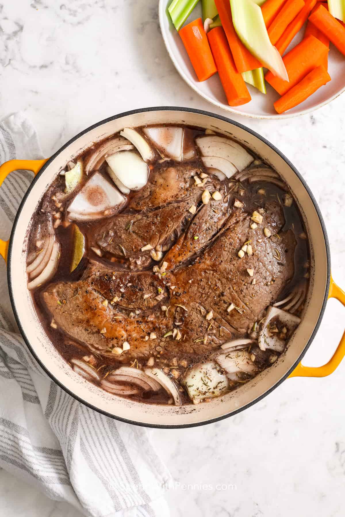 a seared pot roast with onions, seasonings, and red wine in a Dutch oven 