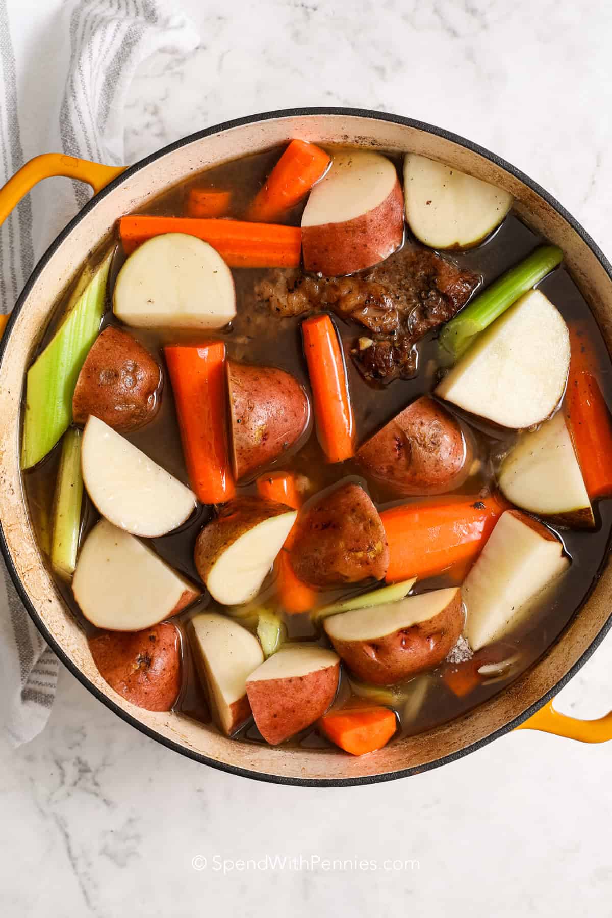 vegetables added to a pot roast in a Dutch oven 