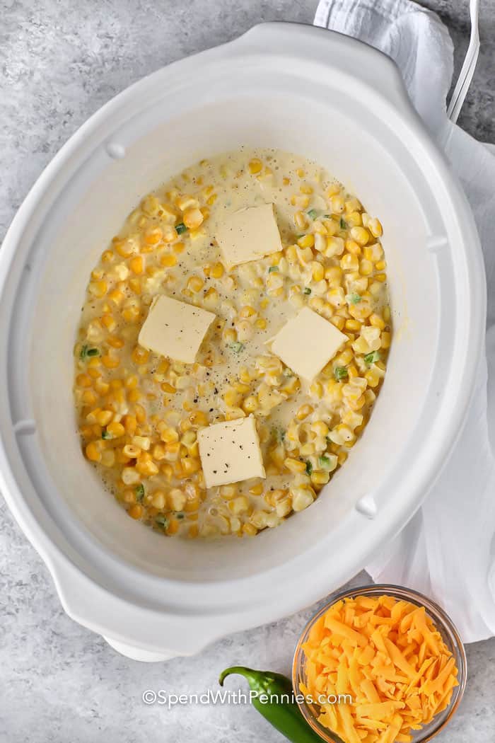 adding butter to crockpot to make Crock Pot Creamed Corn