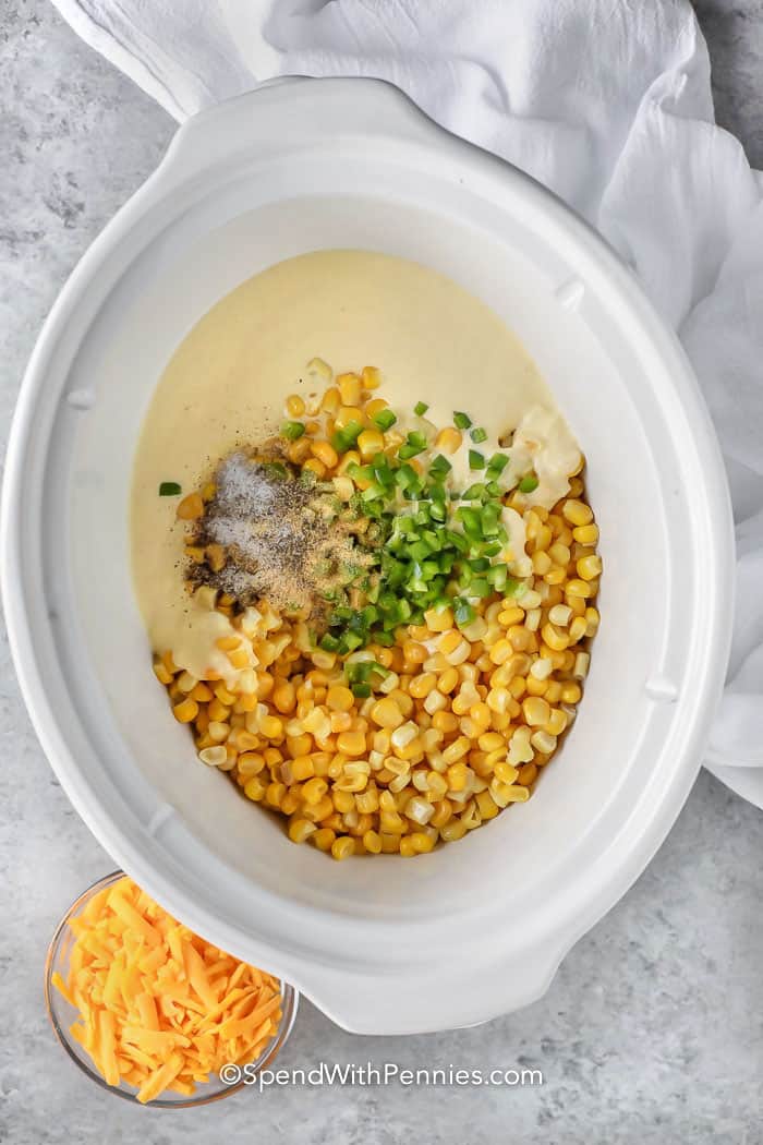 adding ingredients to crockpot to make Crock Pot Creamed Corn