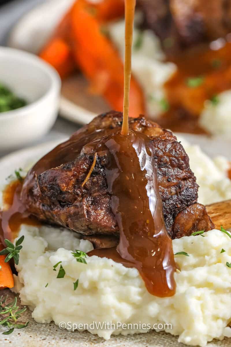 pouring red wine gravy over Slow Cooker Short Ribs