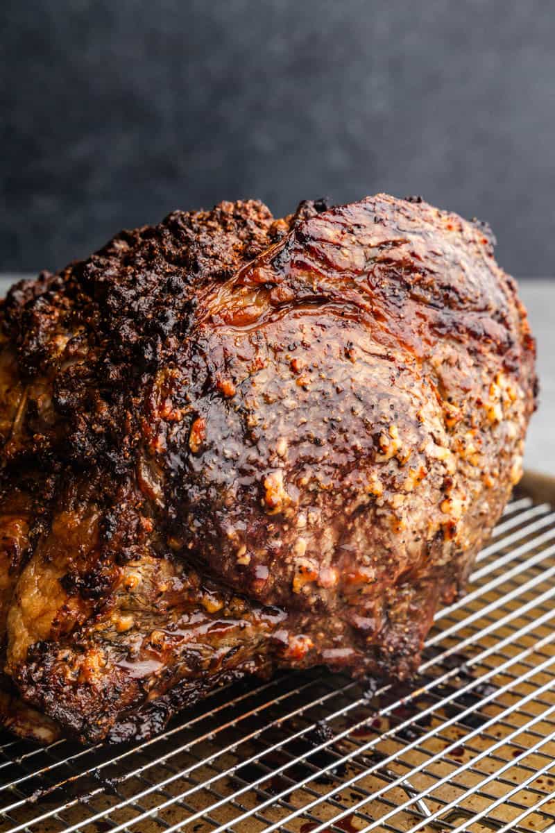 A whole, unsliced horseradish crusted prime rib on a wire rack.