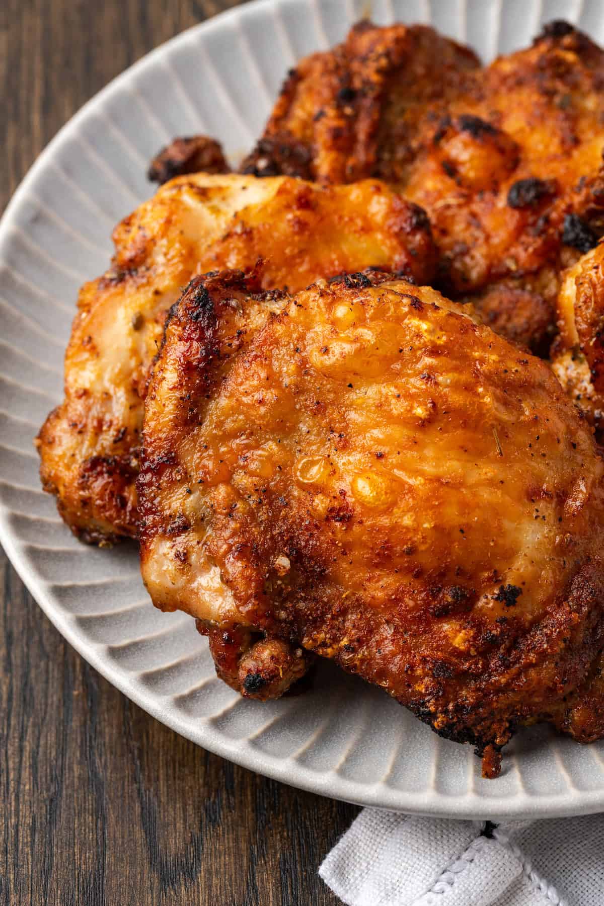 Close up of air fryer chicken thighs on a platter.