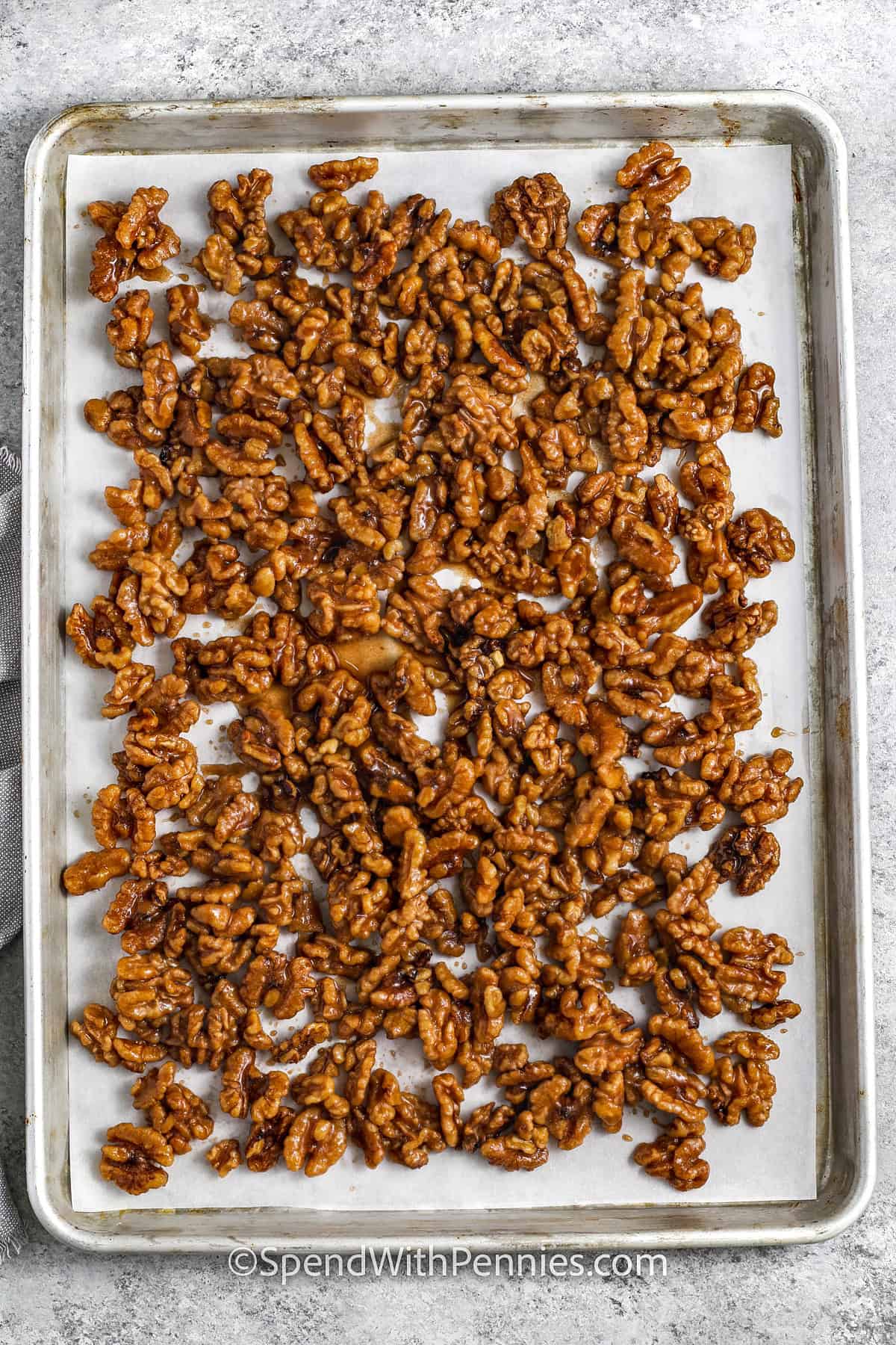 adding Candied Walnuts mixture to a sheet pan