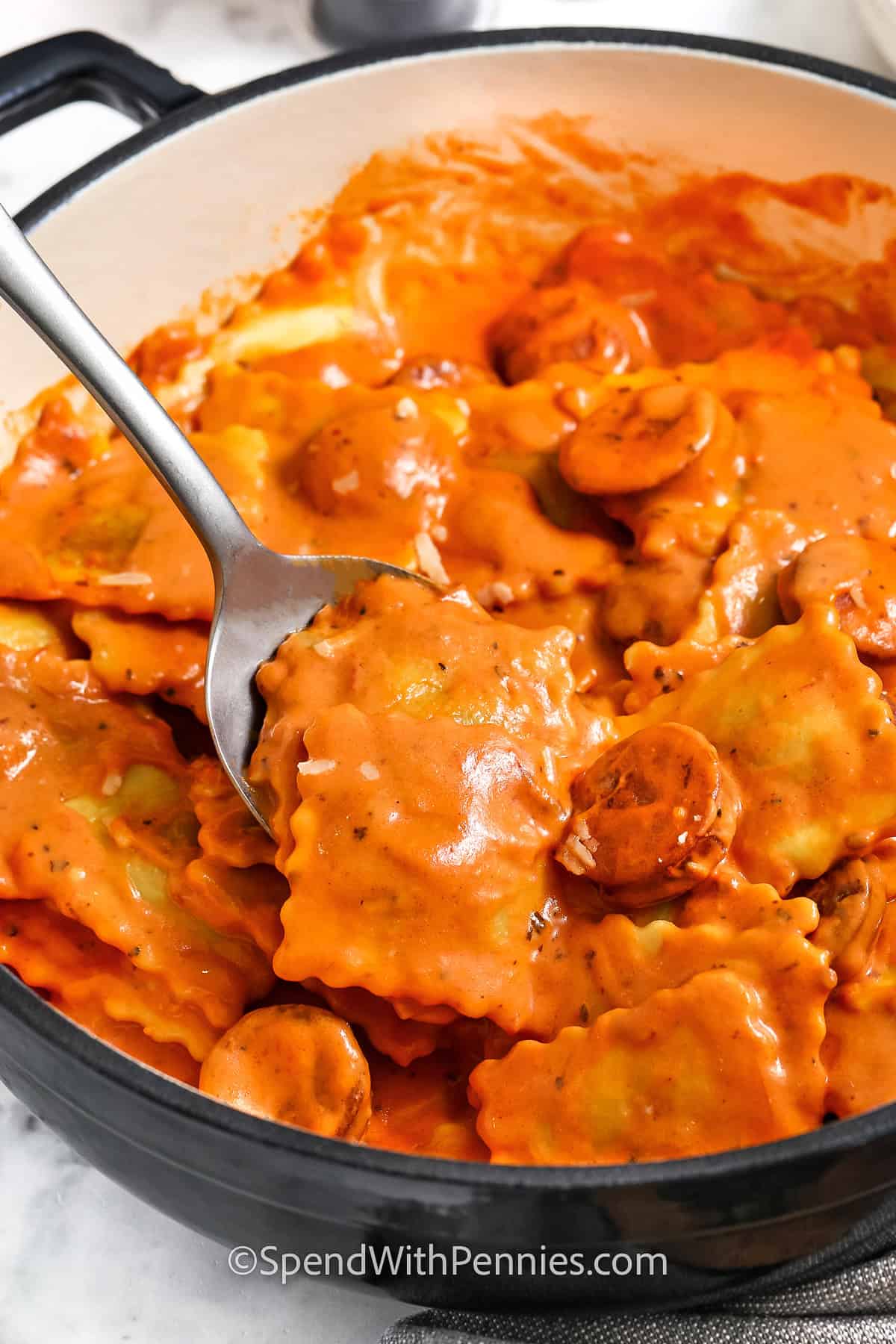 taking a spoonfull of Easy Ravioli with Tomato Sauce out of the pan