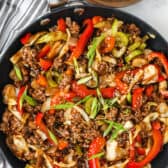 cooked Ground Beef Stir Fry with a bowl of rice beside it