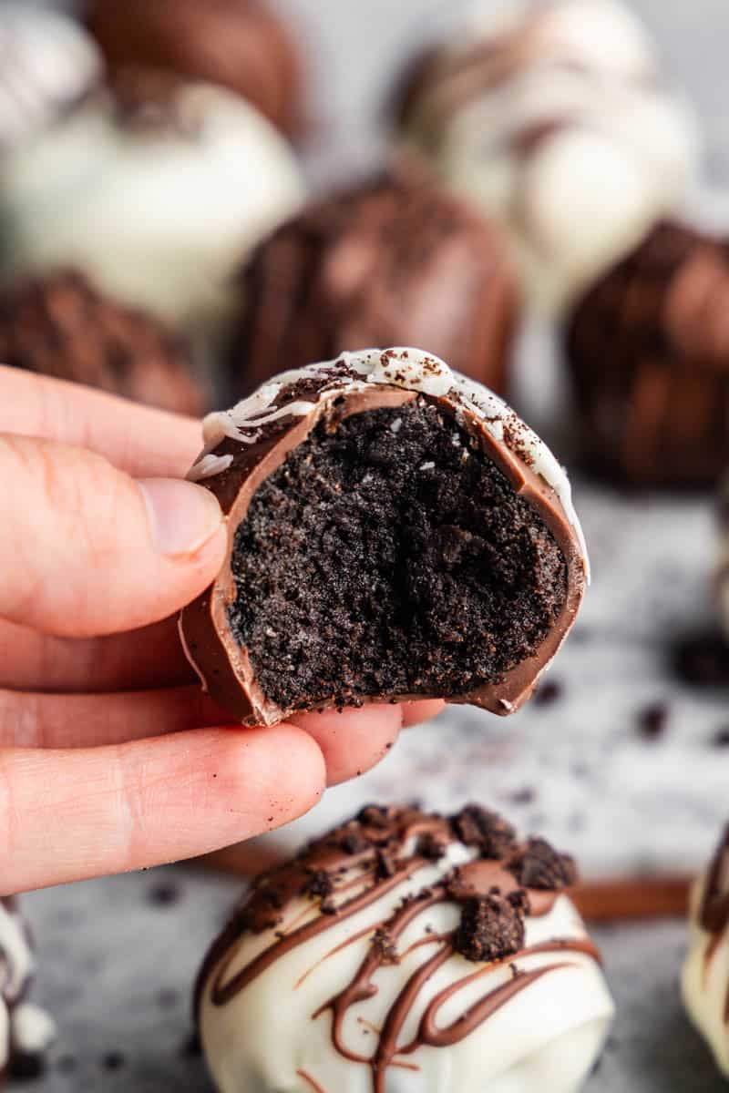 hand holding oreo truffle with bite taken out of it