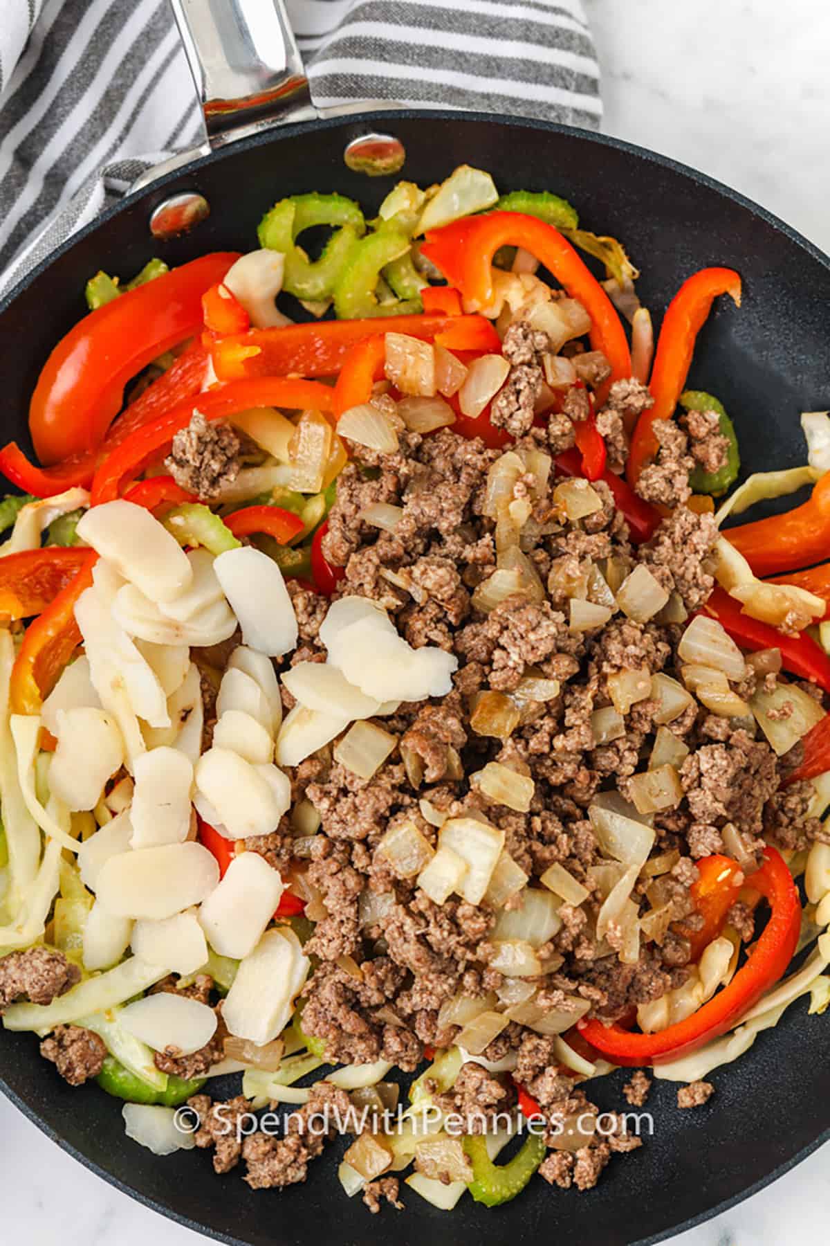 adding ingredients to cooked beef to make Sesame Ground Beef Stir Fry