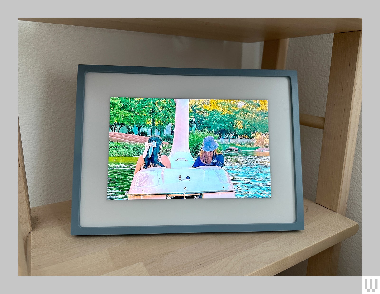 Skylight Frame 2 a thin green picture frame over a touchscreen showing a rear view photo of two people riding in an...