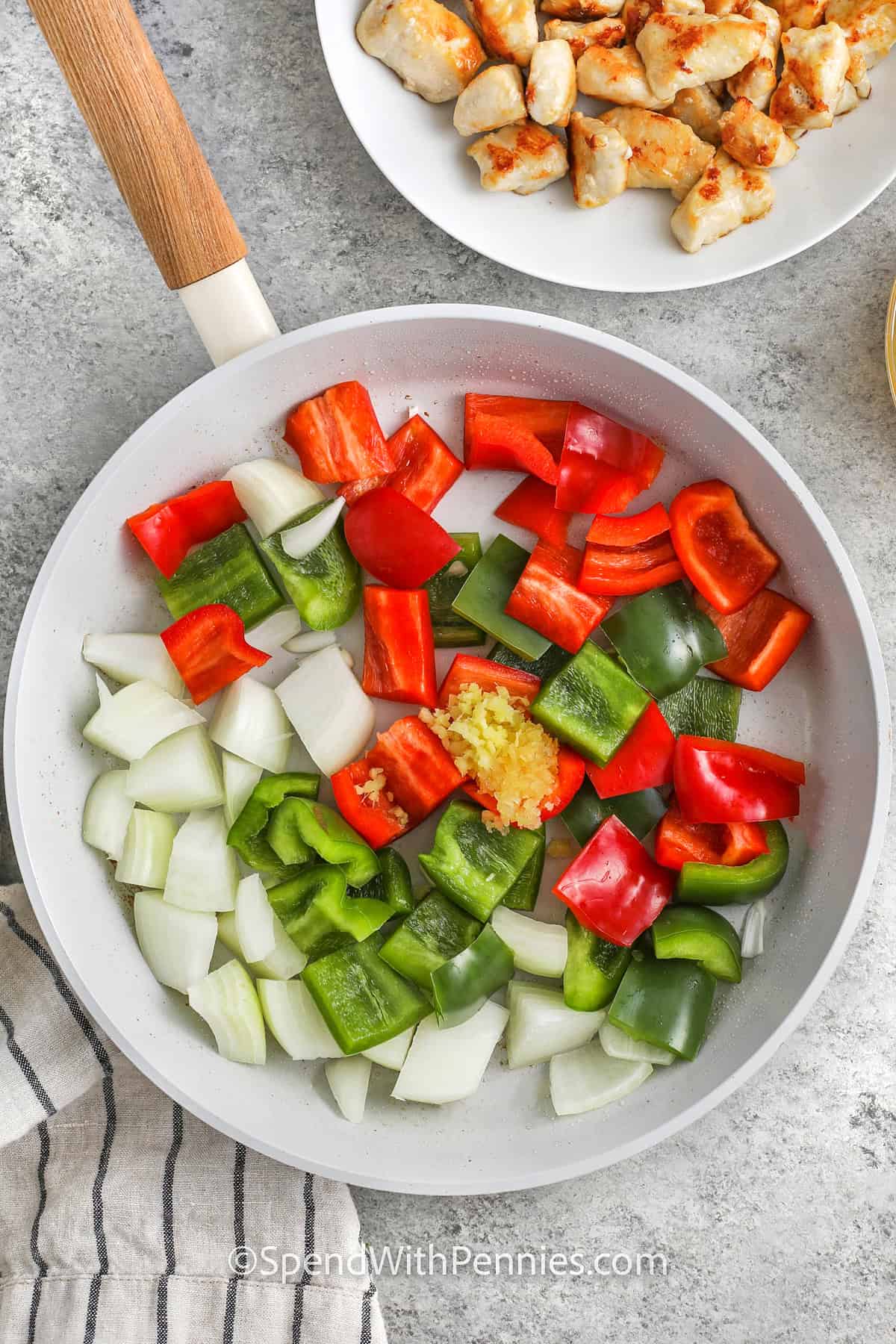 adding vegetables with ginger and garlic to pan to make Sweet and Sour Chicken