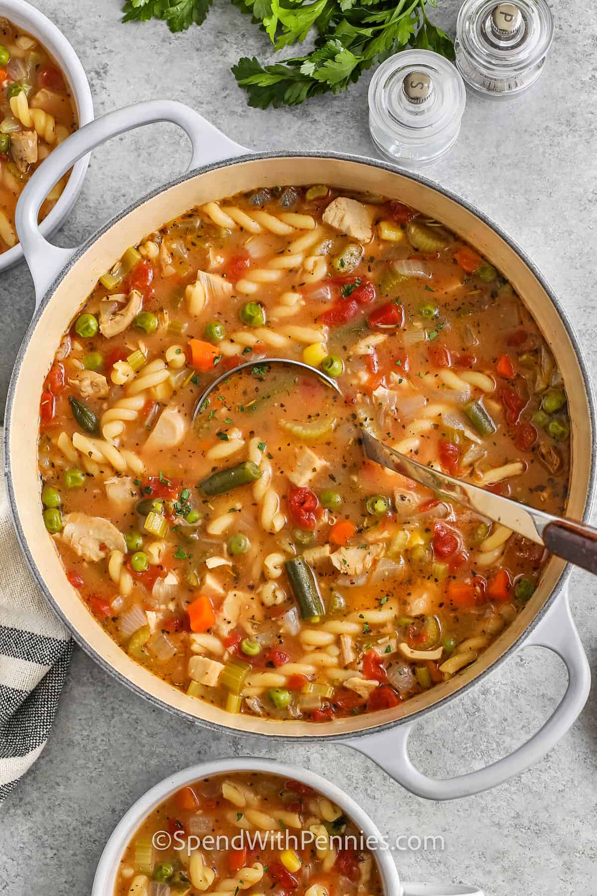 taking a spoonful of Turkey Vegetable Soup out of the pot