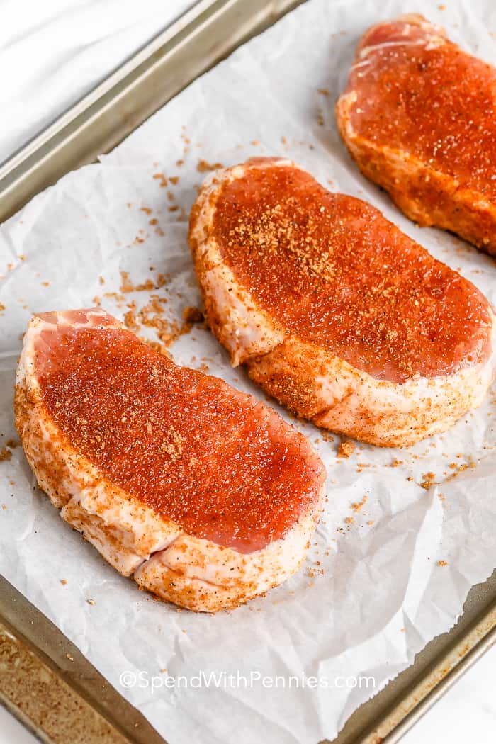 Seasoned pork chops on a baking tray