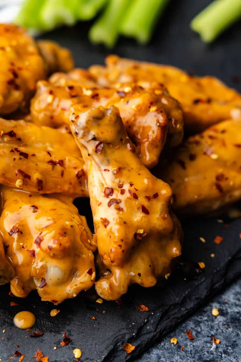 Bang Bang Chicken wings stacked up on a black platter.