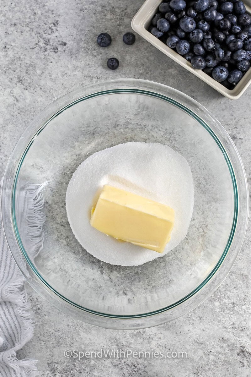 adding butter to sugar to make Blueberry Muffins