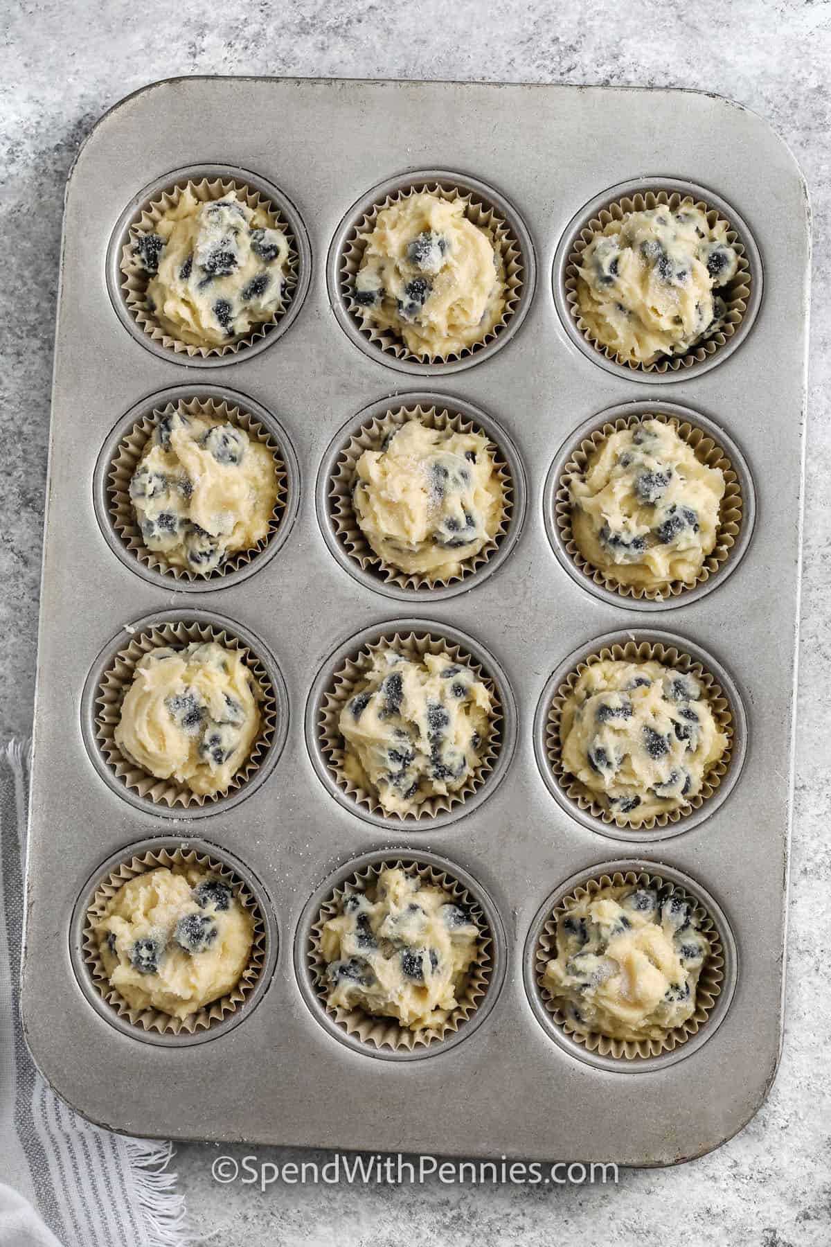 adding Blueberry Muffins batter to mufin tin