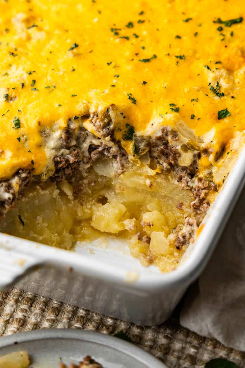 A close up view of a pan of hobo casserole with a helping scooped out.