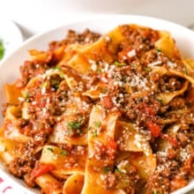 a plate of bolognese topped with parmesan cheese