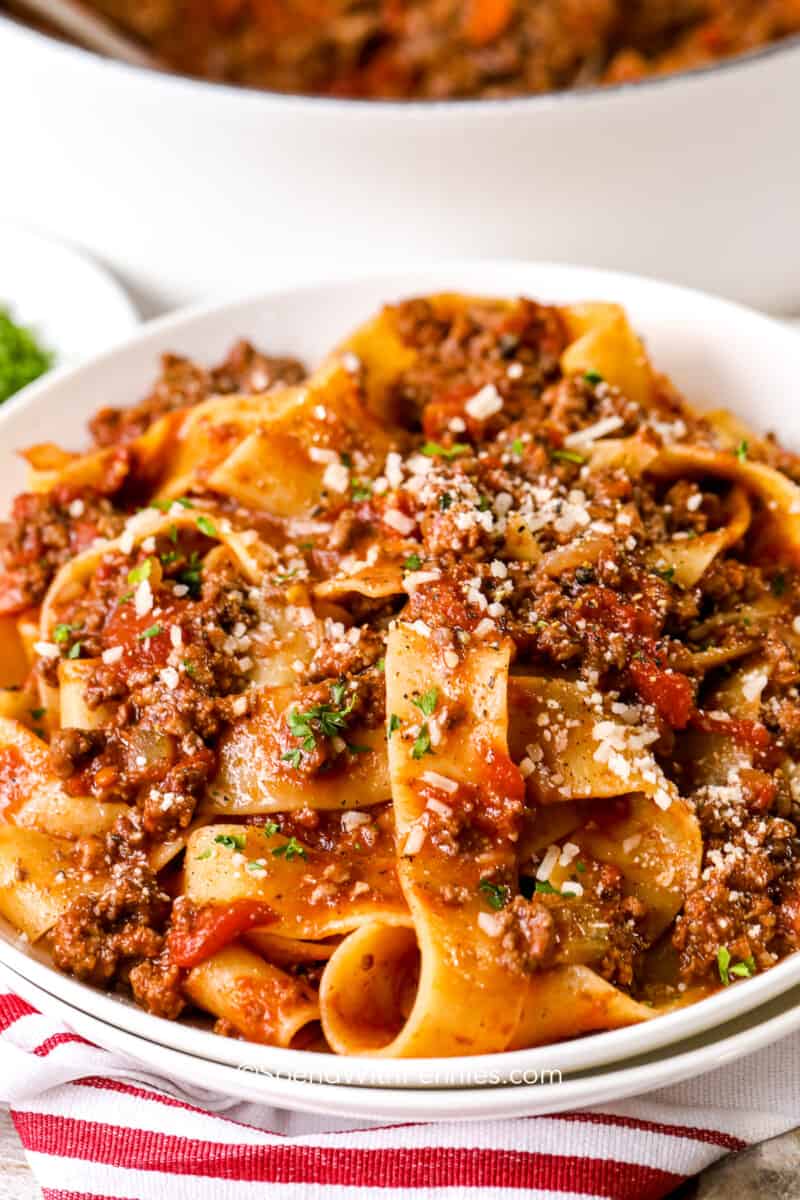 a plate of bolognese topped with parmesan cheese