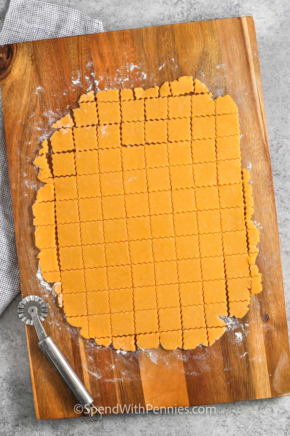 slicing Homemade Cheez-Its dough into squares