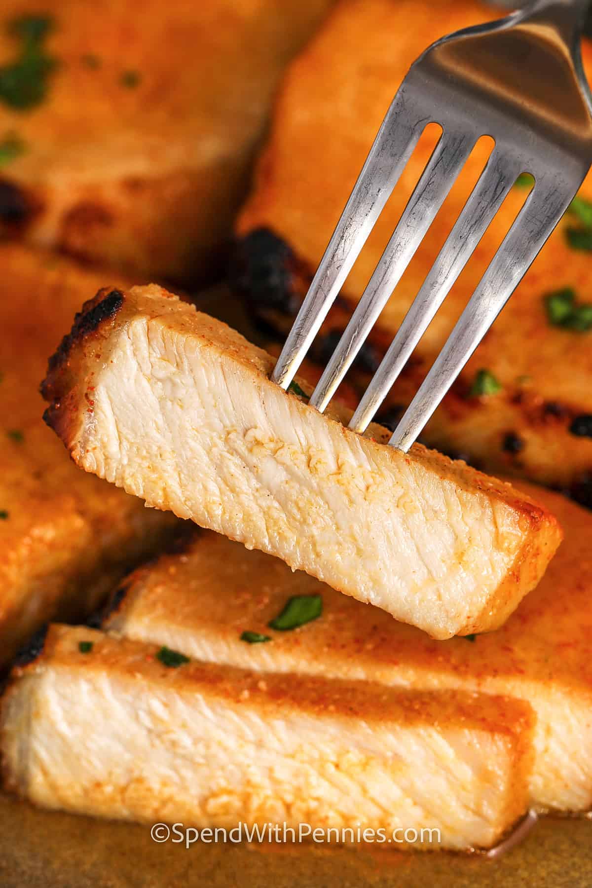 close up of a piece of Juicy Baked Pork Chops on a fork