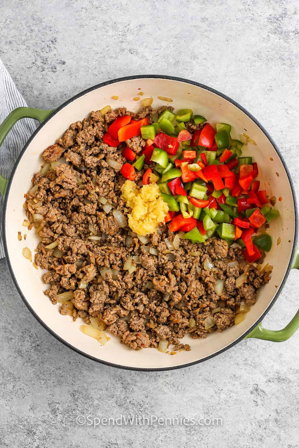 adding garlic and pepperes to cooked beef an onions to make Pizza Pasta sauce