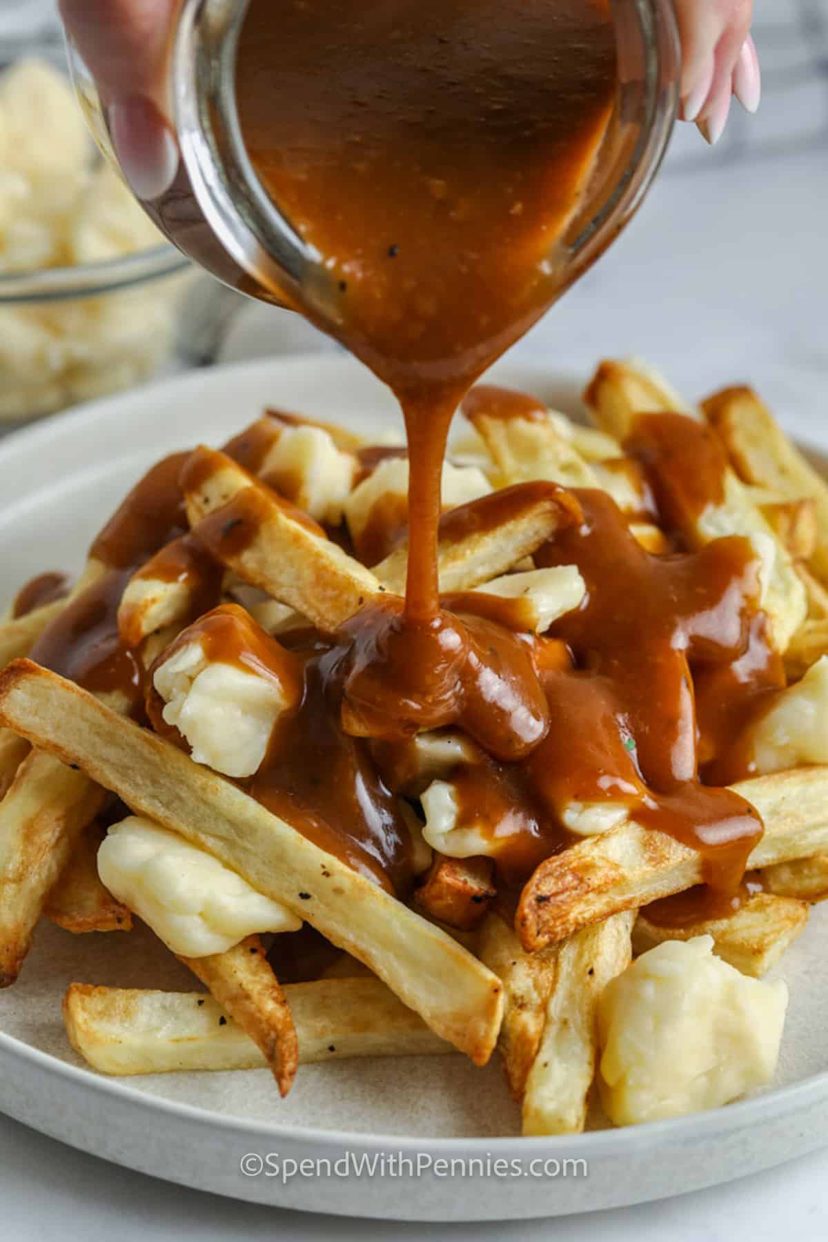 adding gravy to fries to make a Poutine