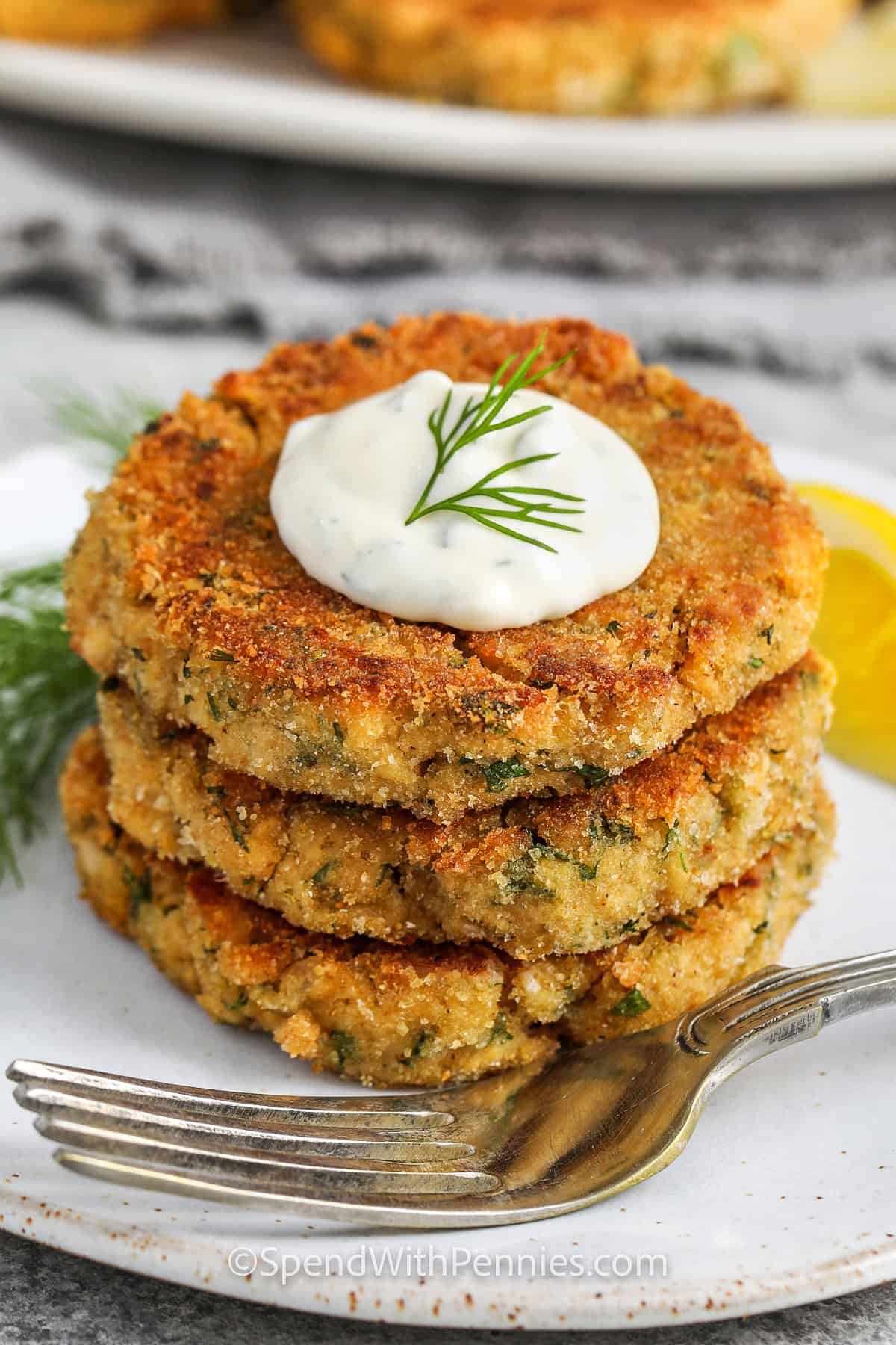 stack of Salmon Patties on a plate with sauce on top