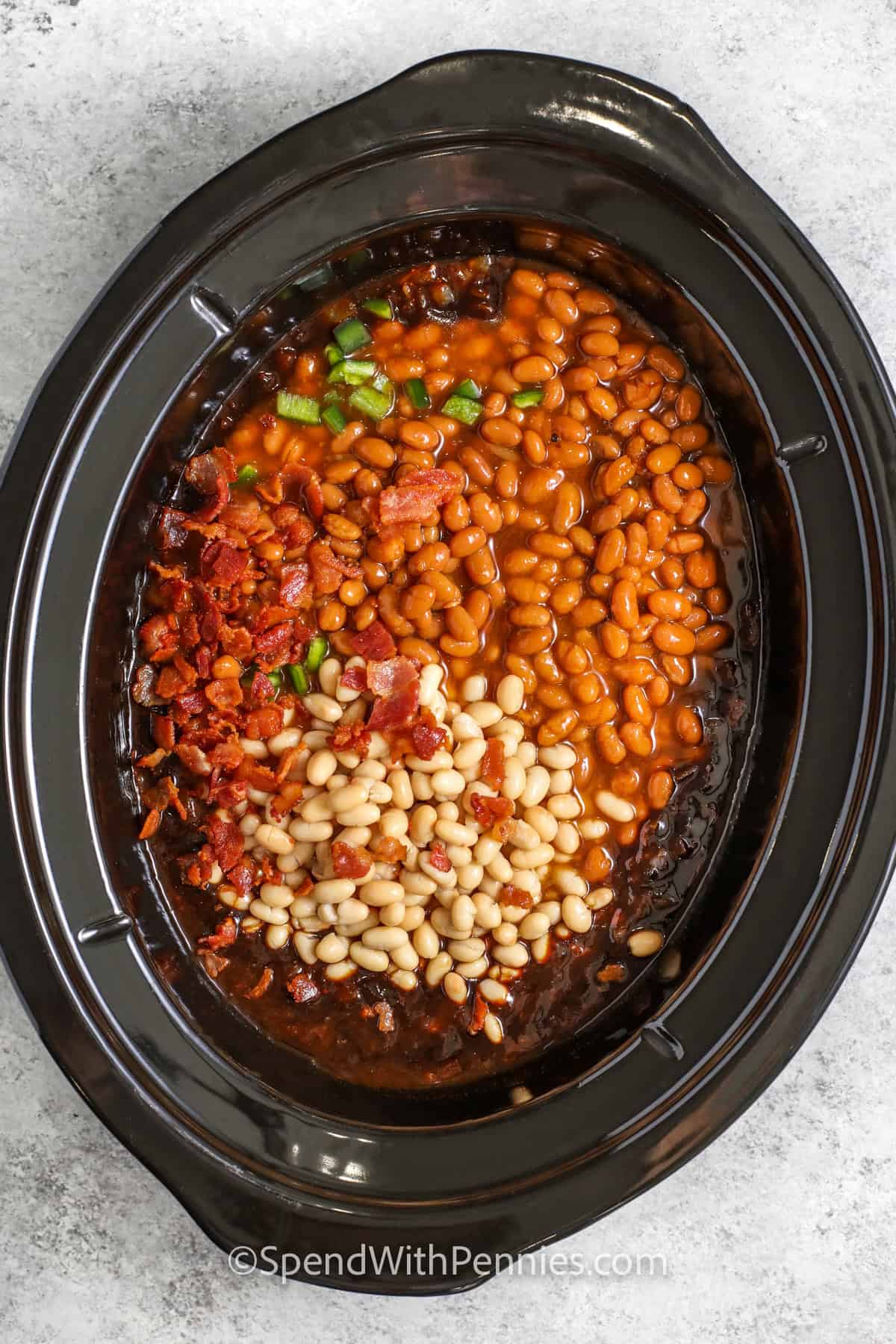 adding beans and bacon to pot to make Slow Cooker Baked Beans