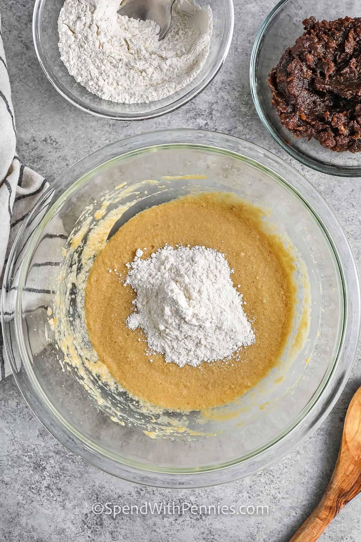 adding dry ingredients to wet ingredients to make Sticky Toffee Pudding