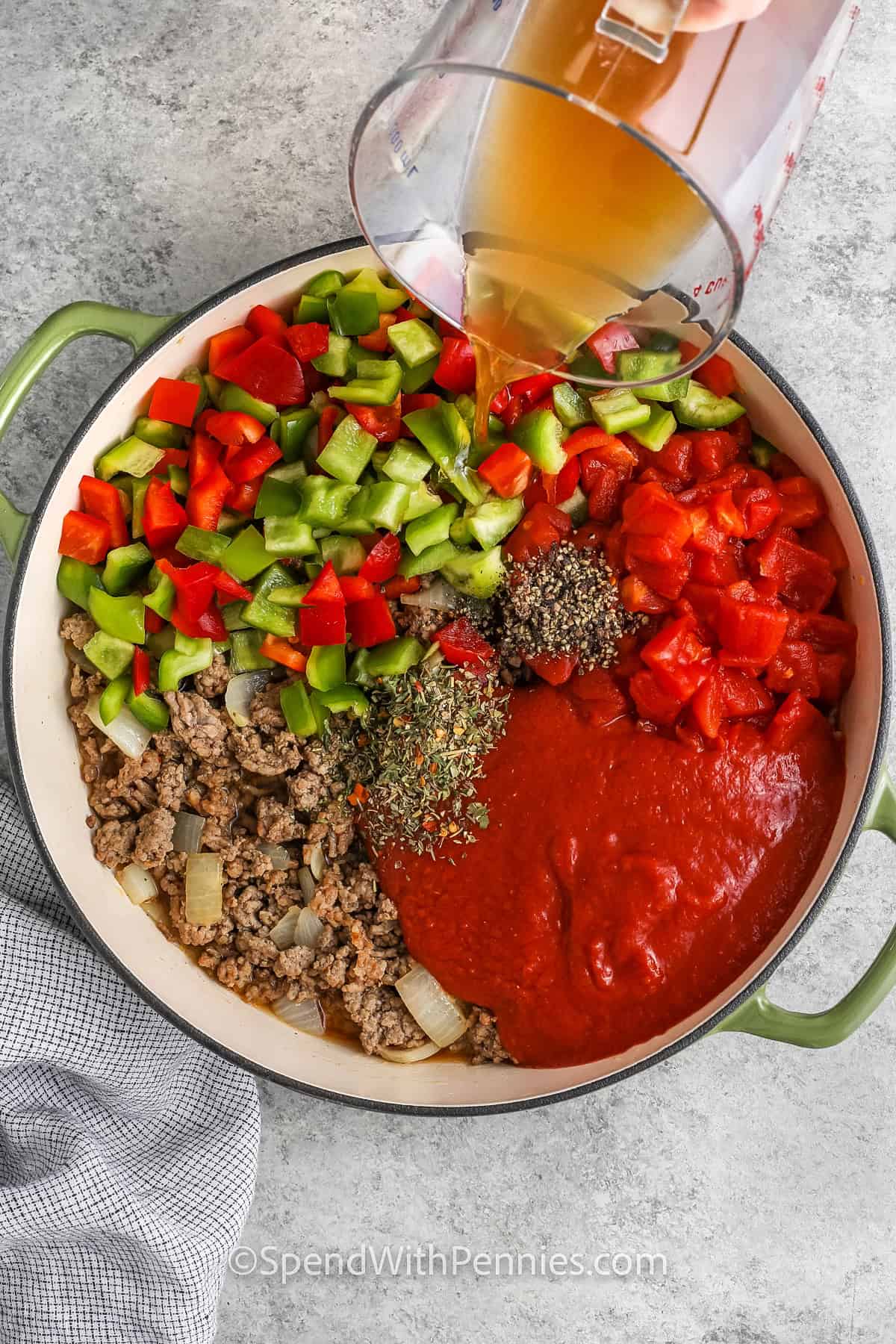 adding broth to ingredients to make Stuffed Pepper Soup