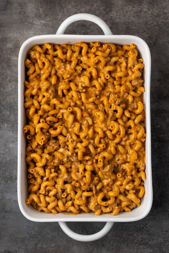 Cheeseburger pasta added to a large ceramic casserole dish.