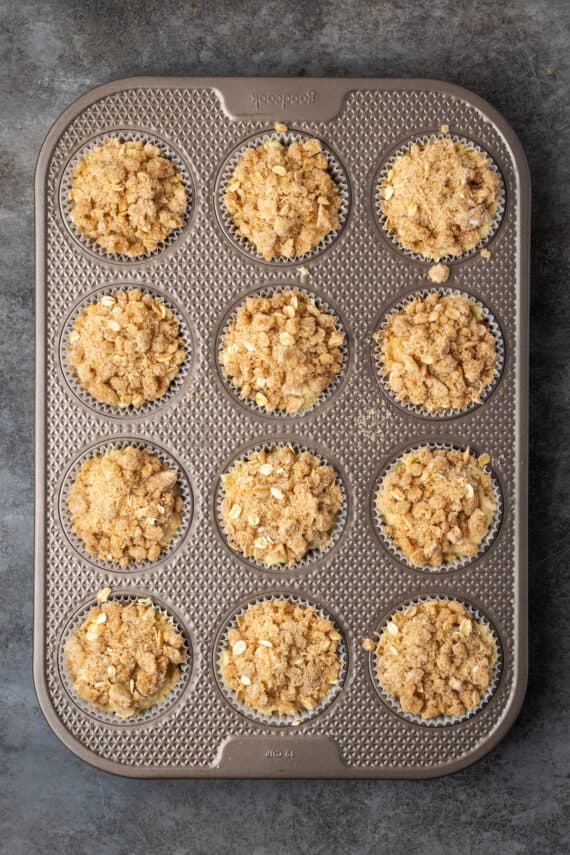 Baked cinnamon muffins in a 12-well muffin pan.