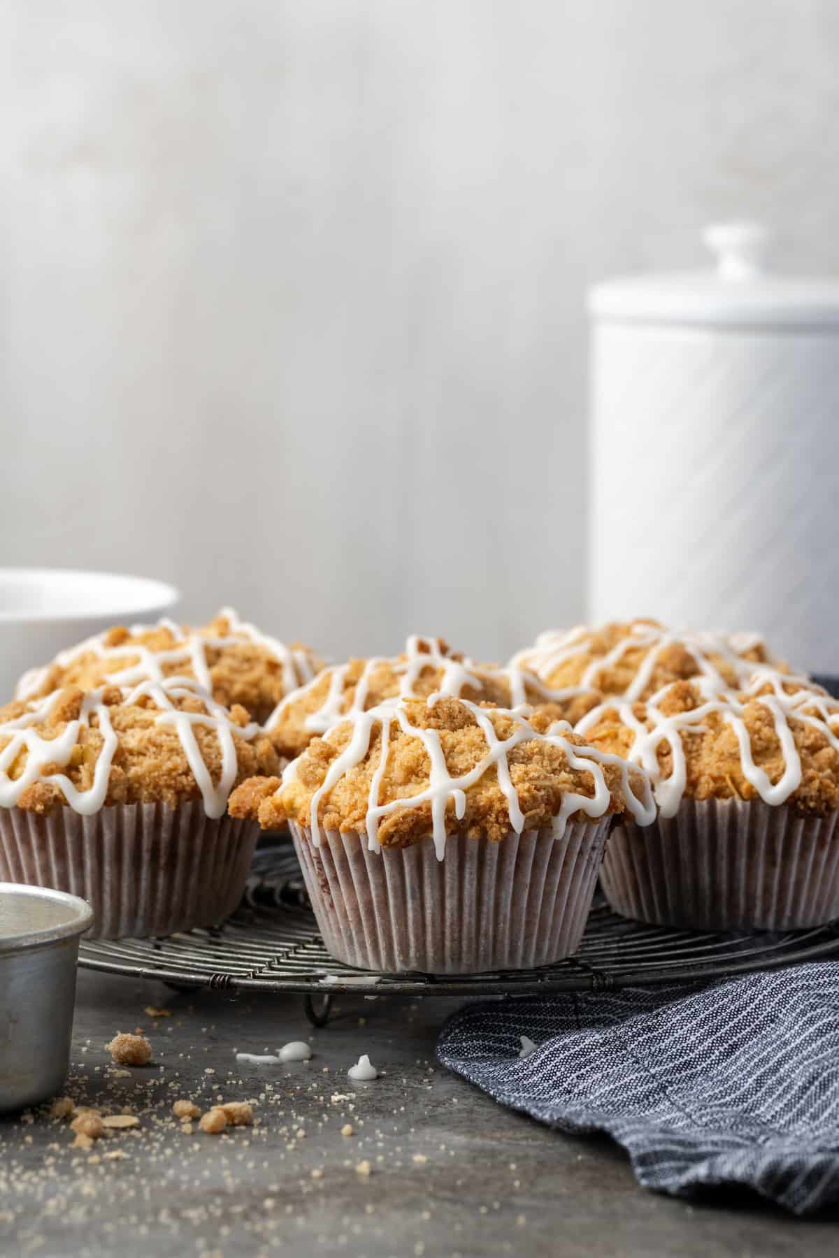 Cinnamon muffins on a wire rack drizzled with glaze.