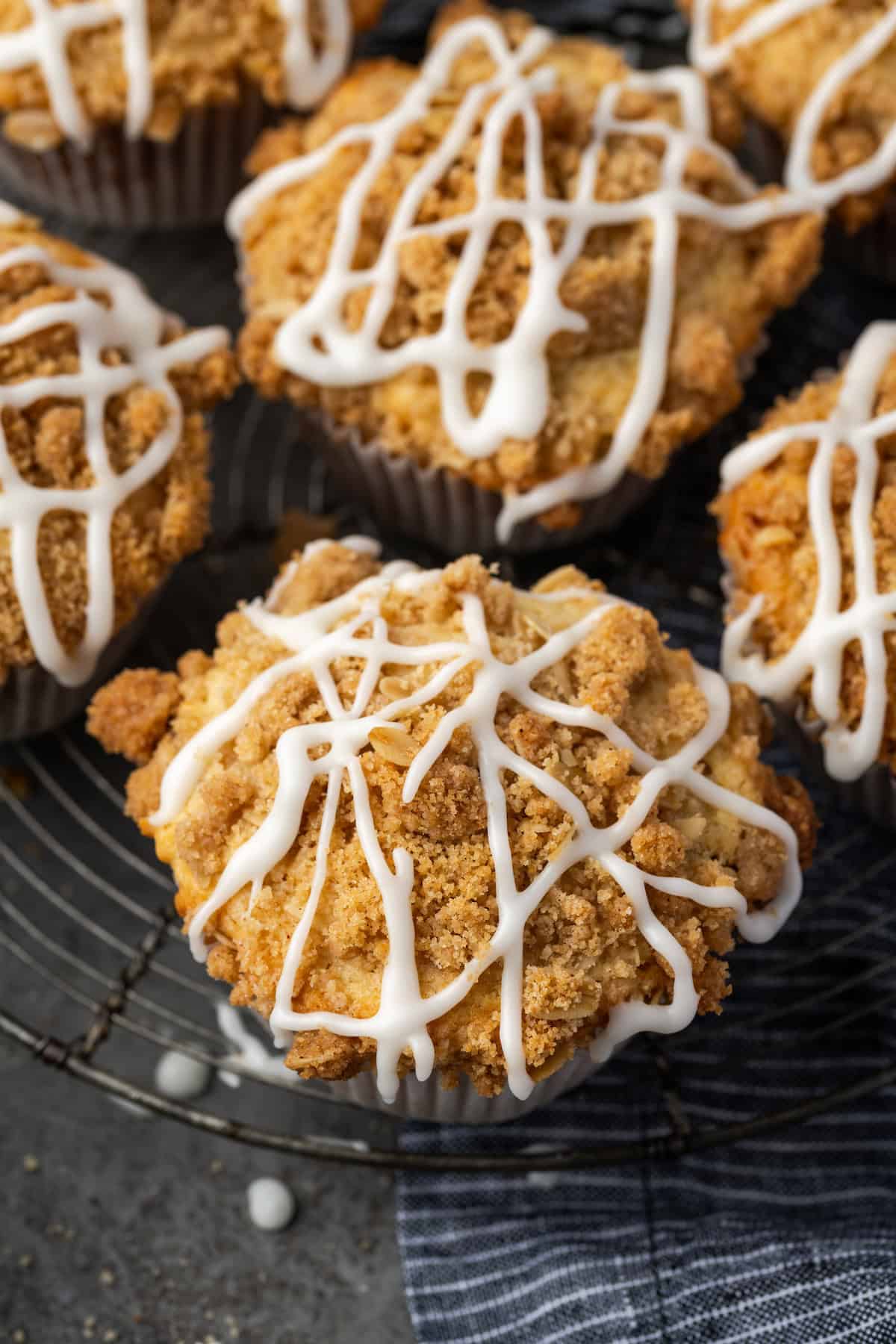 Overhead view of cinnamon muffins on a wire rack drizzled with glaze.