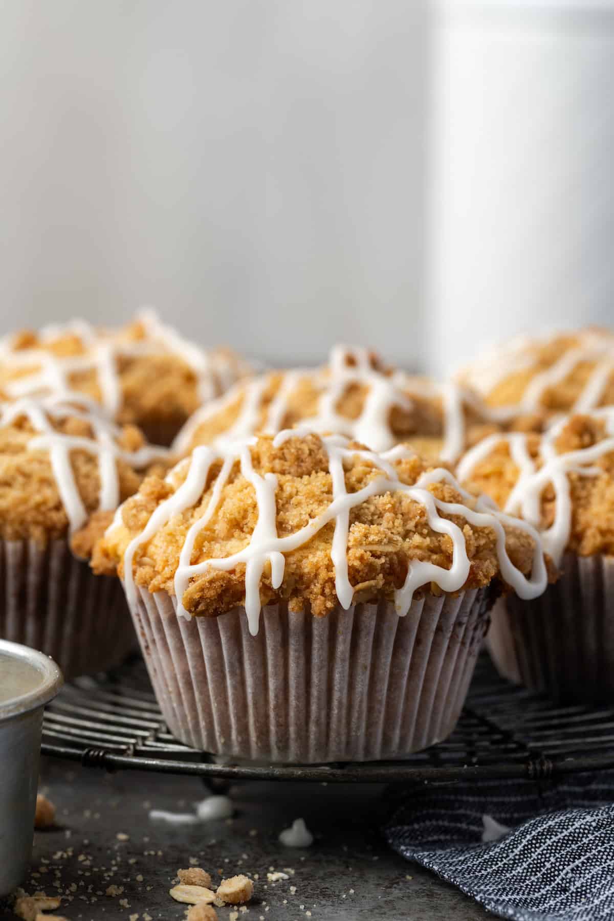 Cinnamon muffins on a wire rack drizzled with glaze.