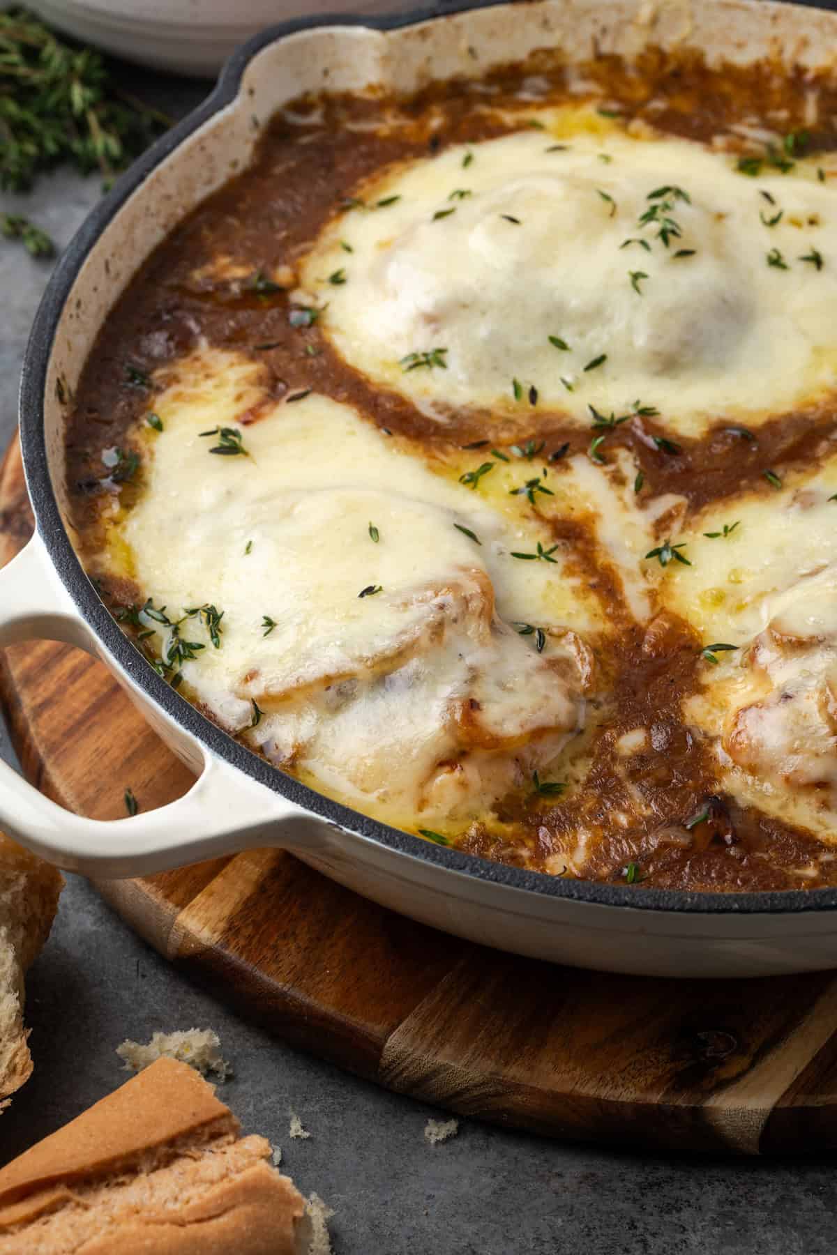 French onion chicken covered with melted cheese in a skillet.